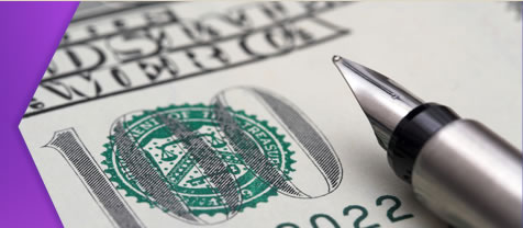 Caligraphy pen laying on hundred-dollar bill